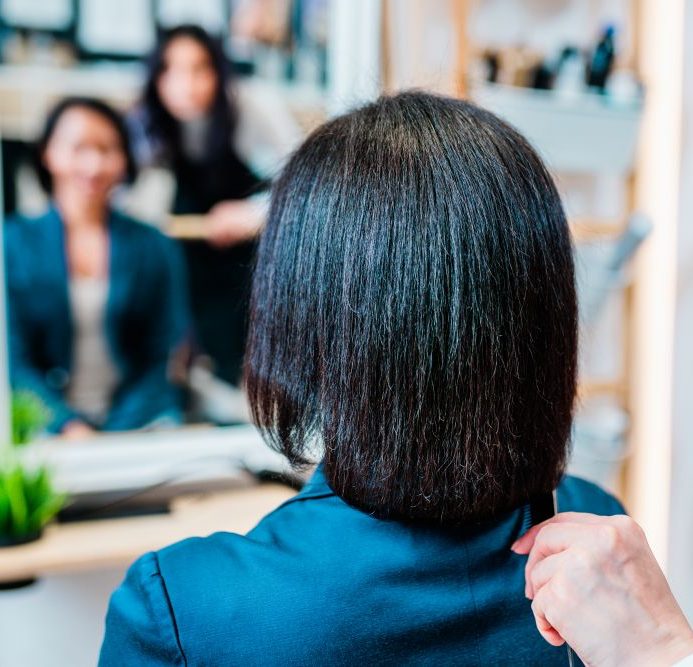 Woman having hair straightened