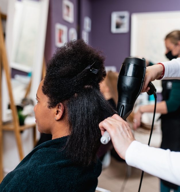 Blowdrying a woman's hair with natural curls